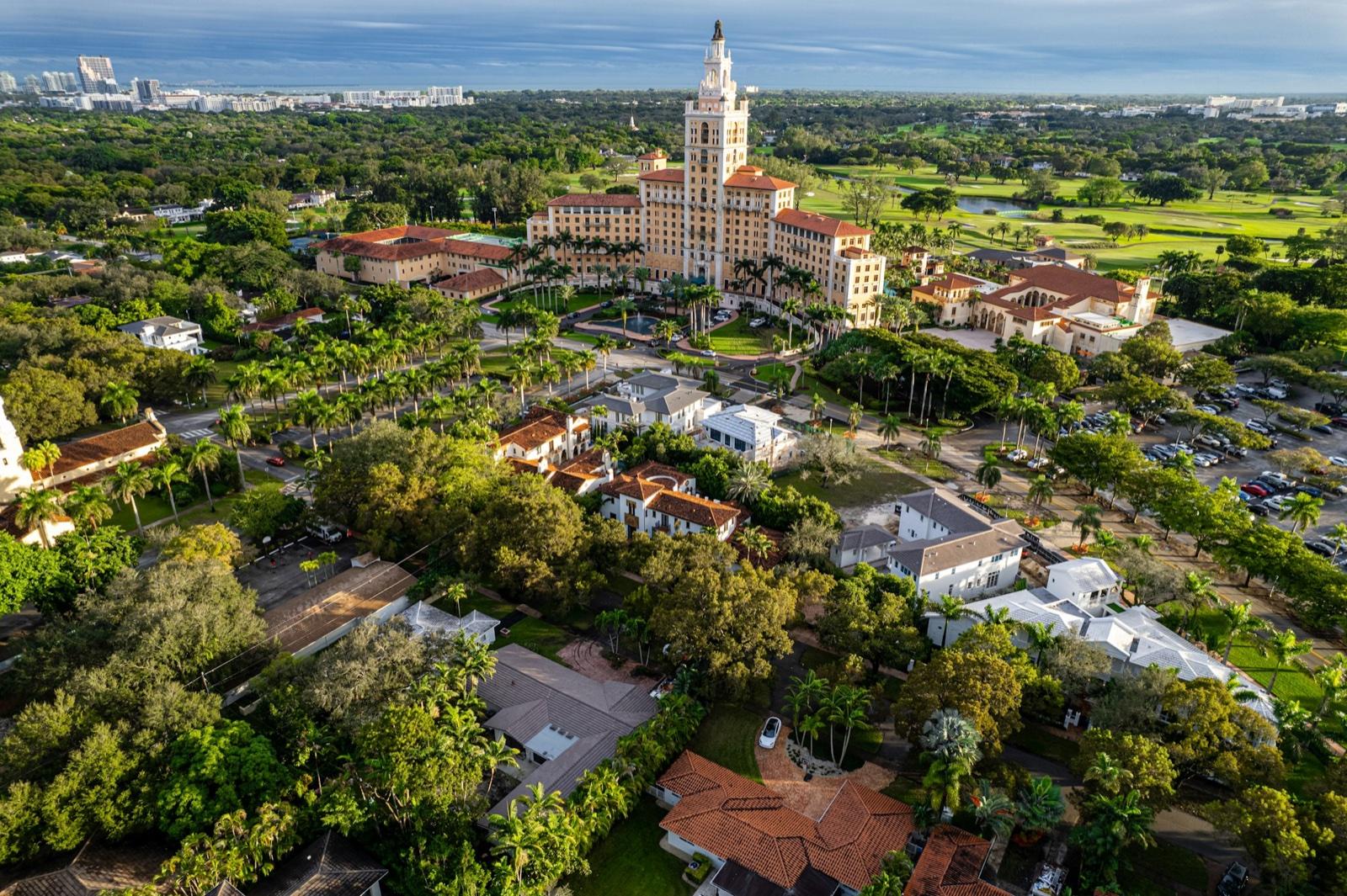 Aerial view of the Biltmore Hotel tower and Coral Gables, with terracotta rooftops among the trees